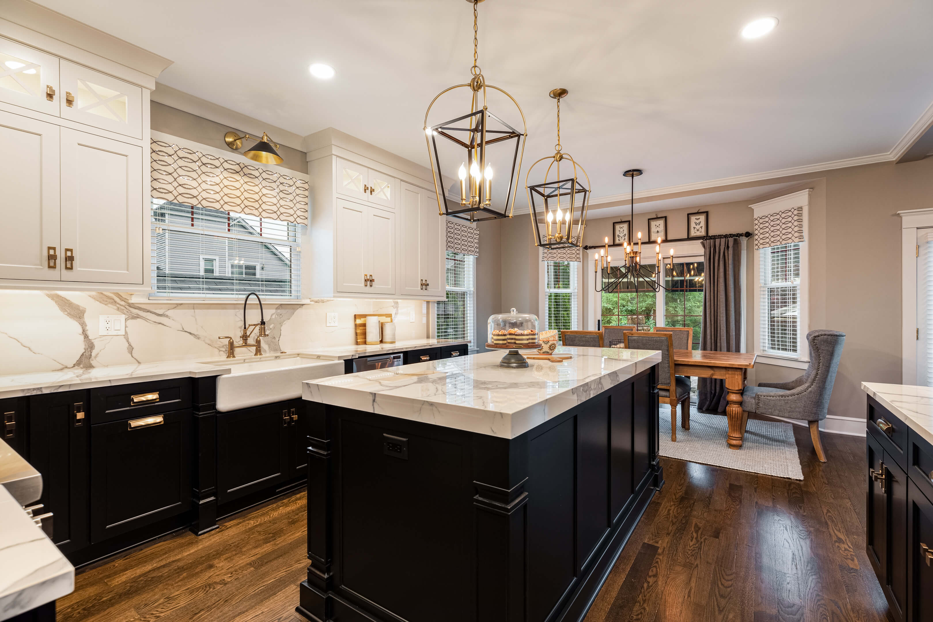 Two-toned kitchen cabinets in off-white and soft gray, including a dresser-style cabinet below the drop-in cooktop.