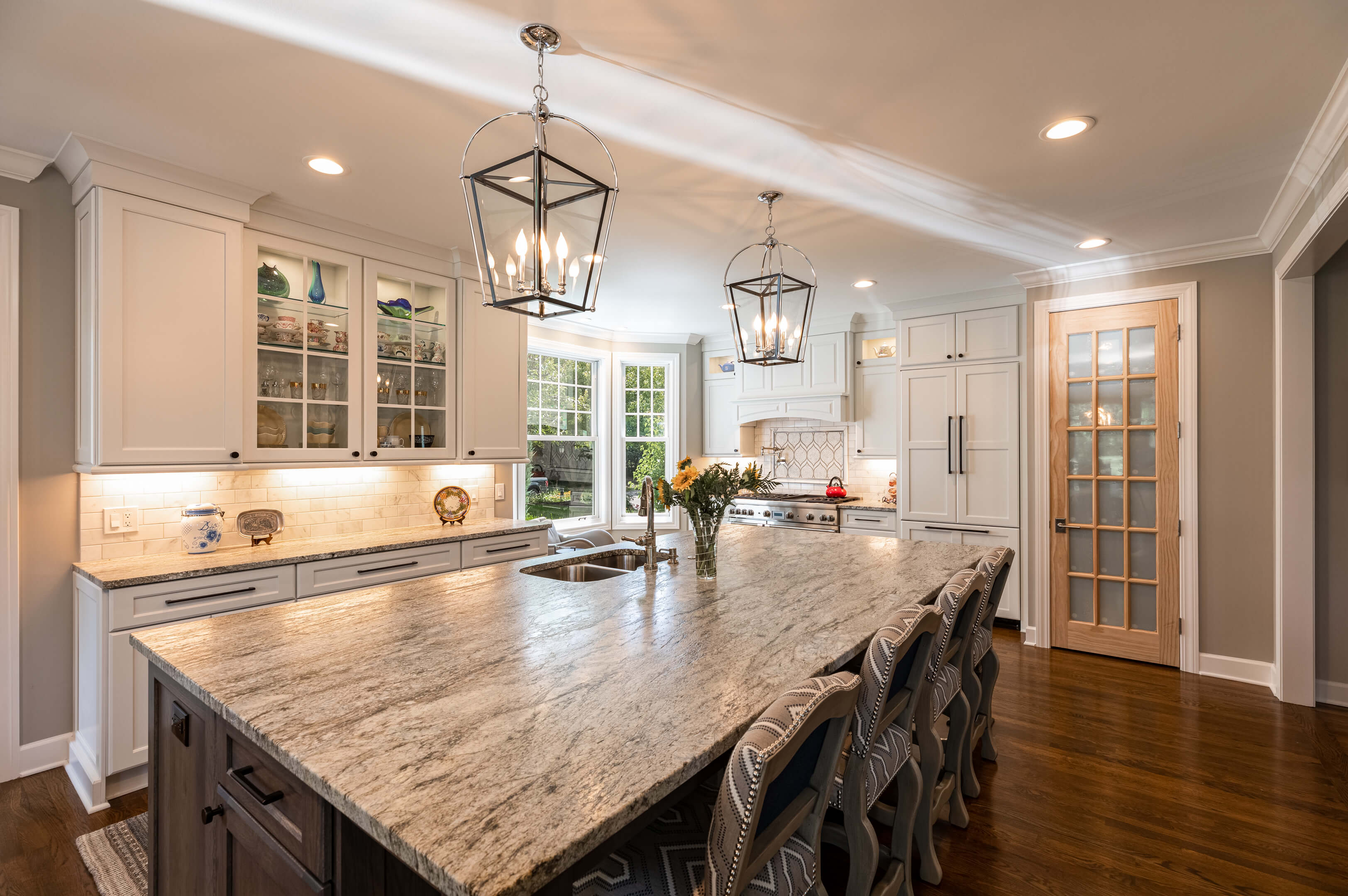 Kitchen with dark stained cabinets, white center work island and separate snack bar.